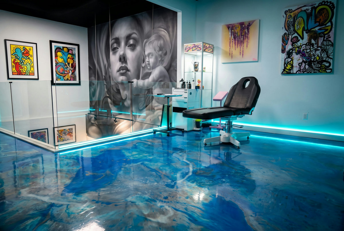 Tattoo chair on a marbled blue resin floor surrounded by colourful art
